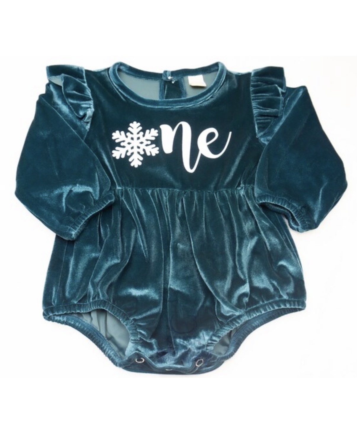 Baby girl in purple Onederland snowflake romper for 1st birthday cake smash photoshoot.