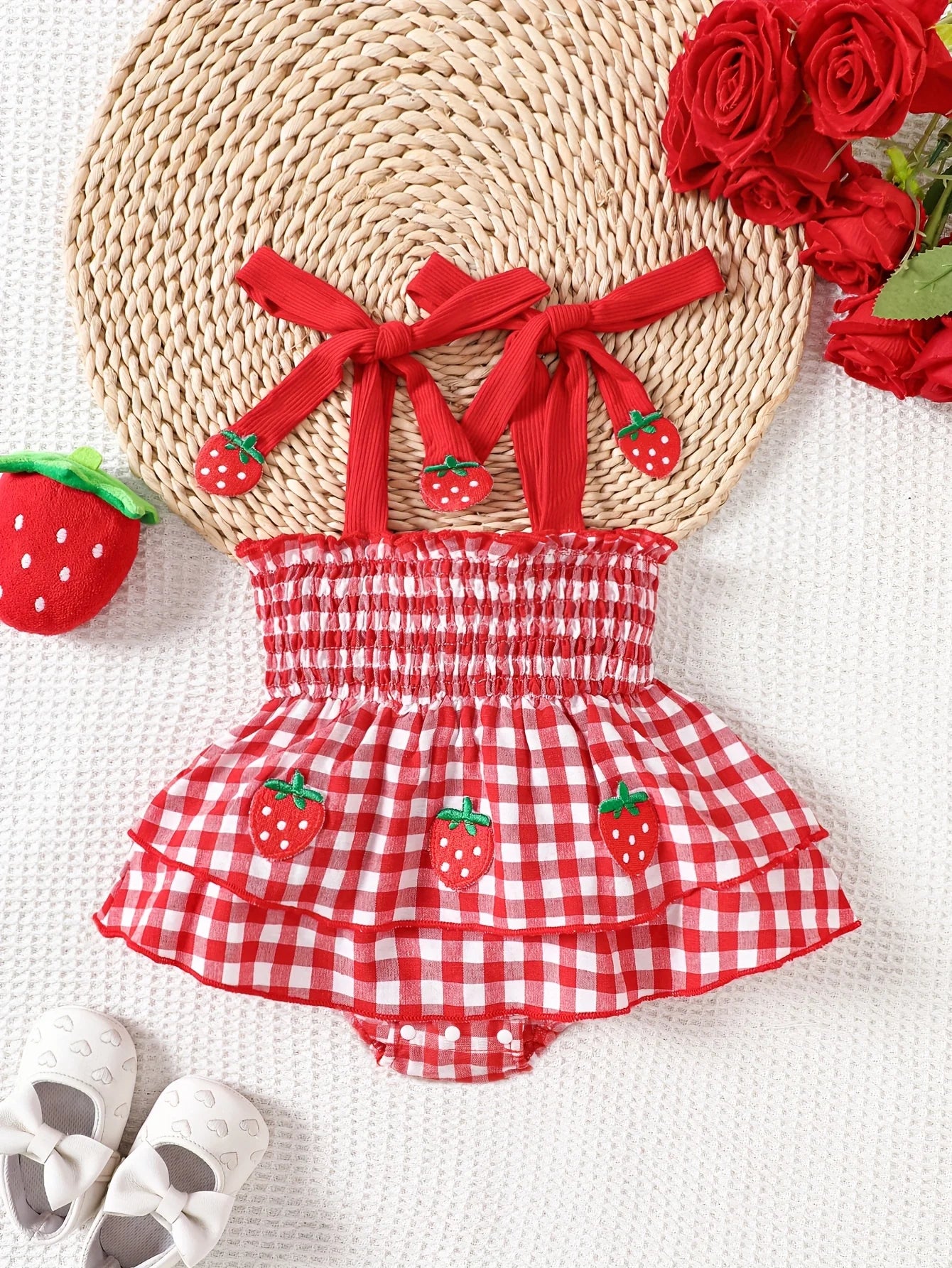 Red and white checkered romper with strawberry design on a white background