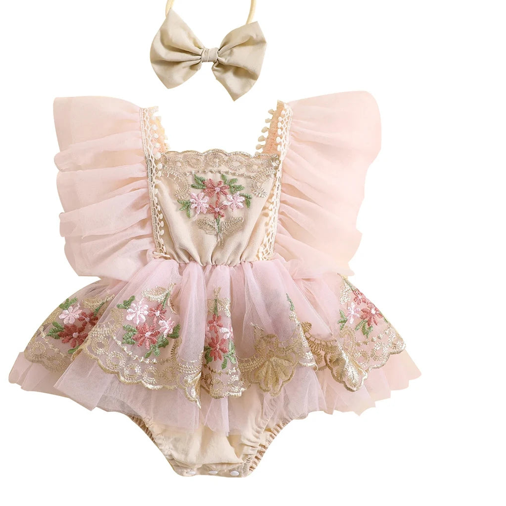 Baby outfit with pink floral romper and headband on a white background