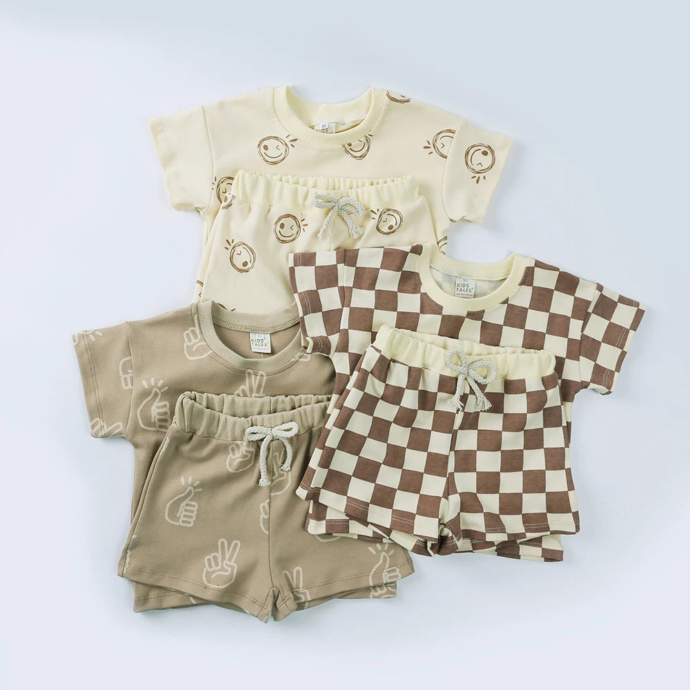 Set of children's clothing including shirts and shorts on a light blue background