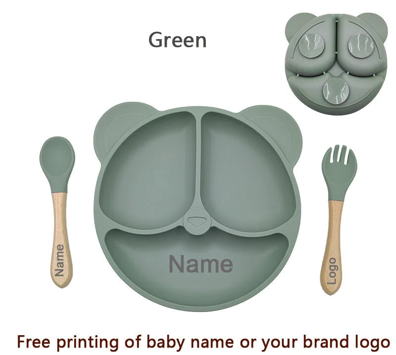Children's dining set with green bear-shaped plate, spoon, and fork on a white background.