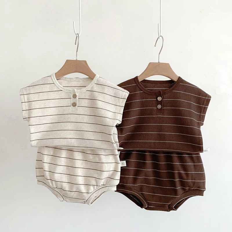 Two striped baby rompers, one beige and one brown, on hangers against a white background.