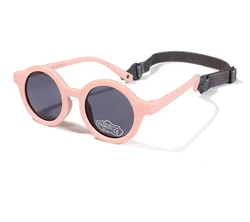 Pink sunglasses with a black strap on a white background, featuring the Mokduff brand.