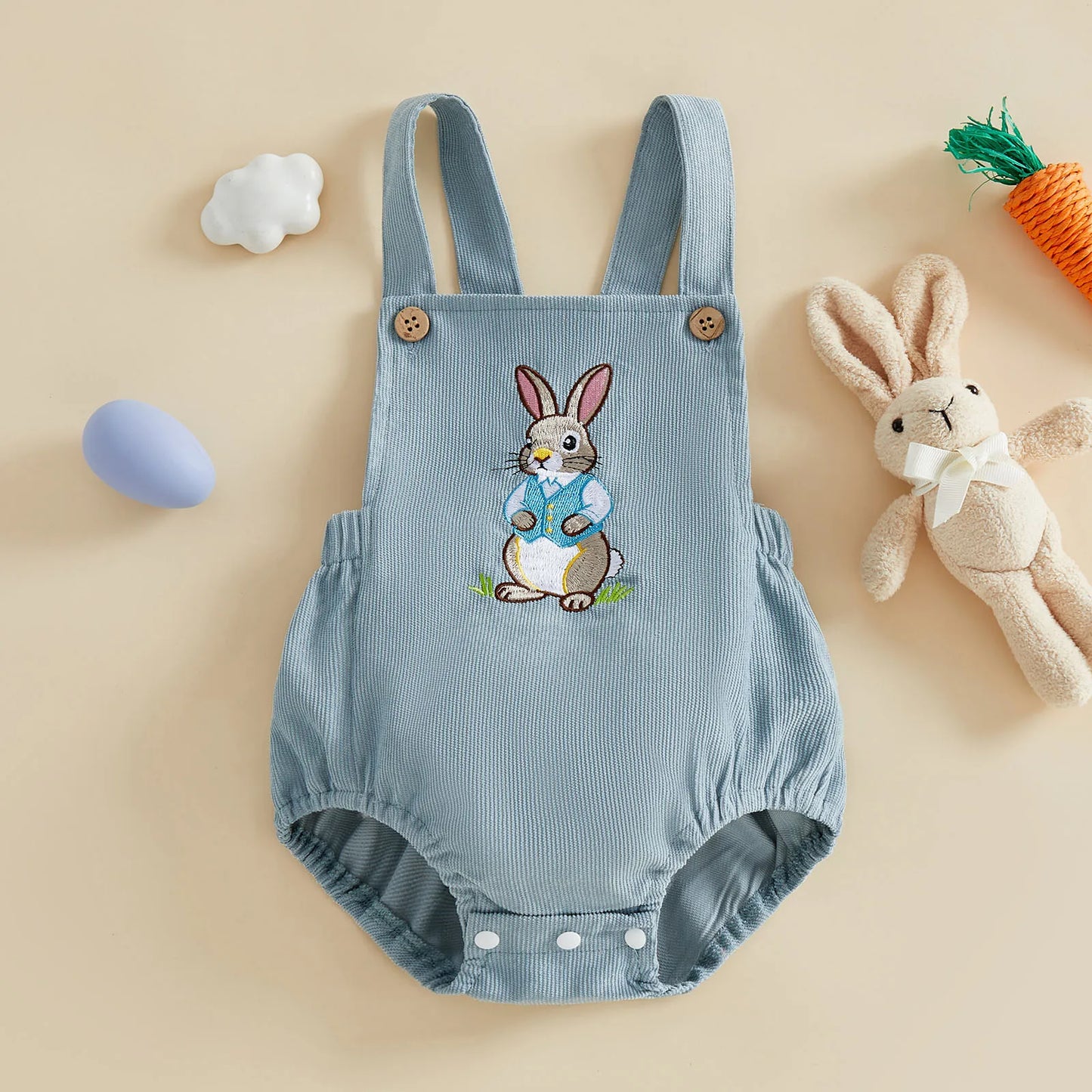 Blue baby romper with bunny design on a beige background