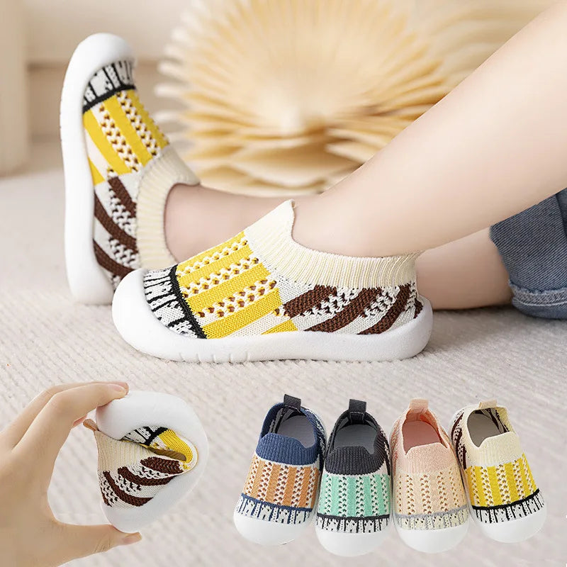 Colorful baby shoes with striped pattern worn by a child, with additional pairs displayed below.