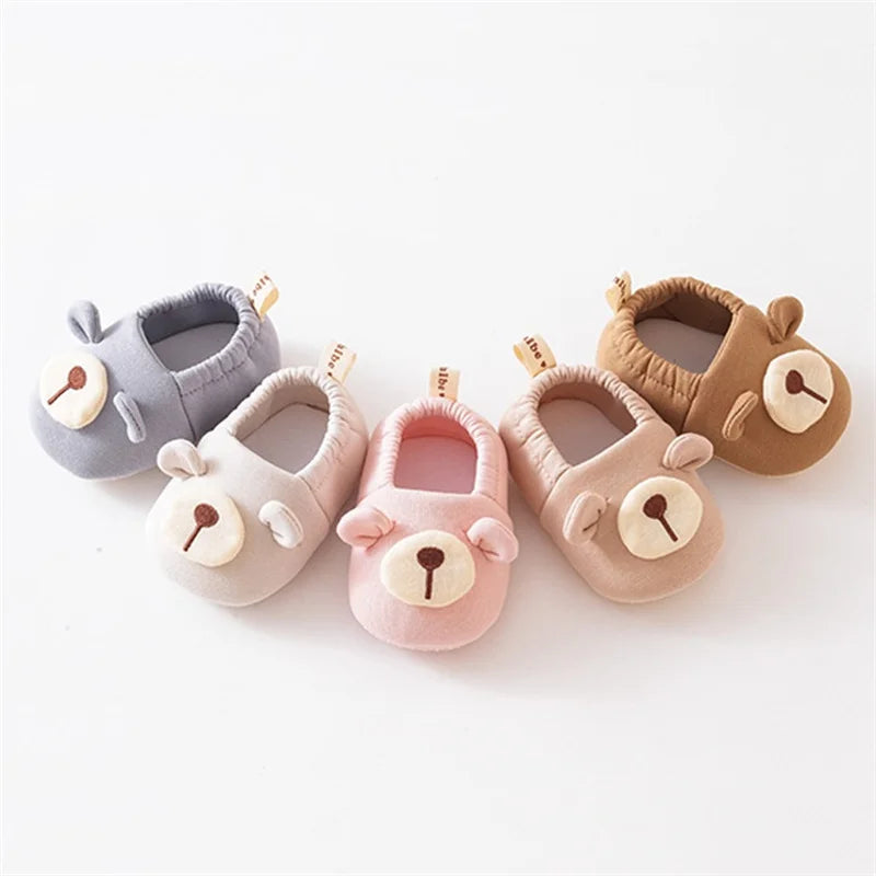 Set of five baby shoes with bear faces on a white background