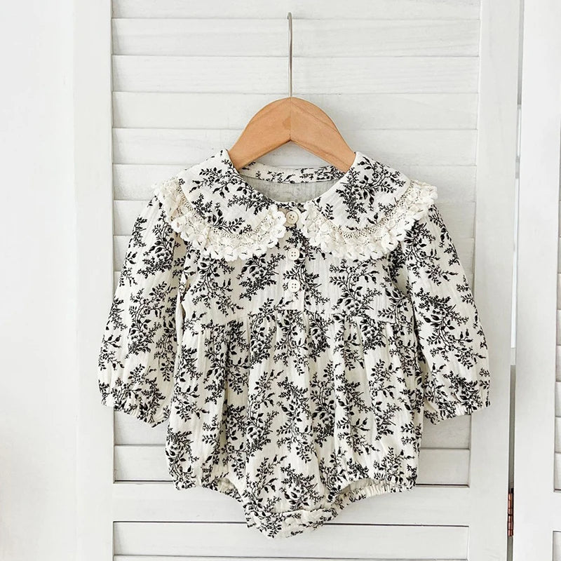 Floral blouse on a wooden hanger against a white wooden panel background